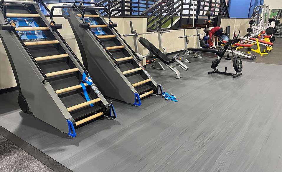 Variety of exercise equipment on a calendered rubber gym flooring.